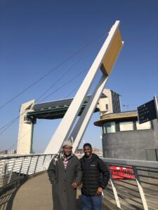 Blessing conducting a walking interview with a participant at the Hull Tidal Barrier in Hull, UK, as part of participatory flood resilience research.