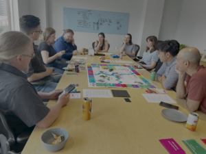 Participants gathered around a board game during a serious game workshop in Calgary, discussing flood resilience.